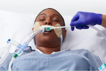 Healthcare worker performing oral decolonization on Intubated patient