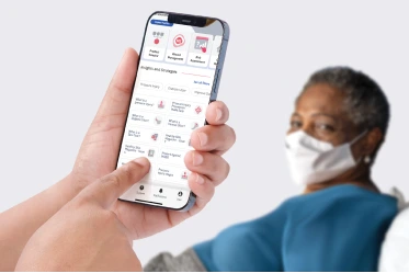 IPhone showing Skin Health app with patient in background