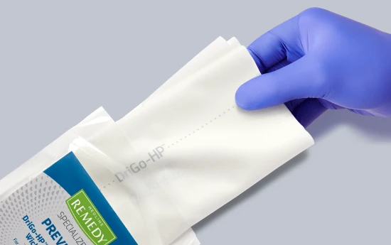 remedy_drigo_form_image Remedy DriGo-HP product sample being removed from packaging by caregiver’s gloved hand