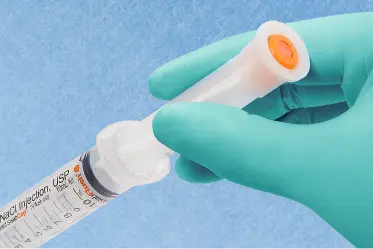 step-sterile Gloved hand holds a saline syringe