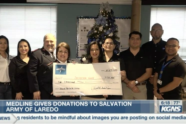 A photo of a group of workers holding an oversized donation check to the Salvation Army of Laredo