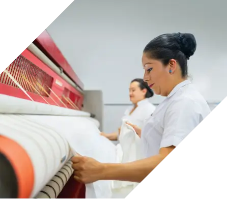  2 workers on industrial laundry machine