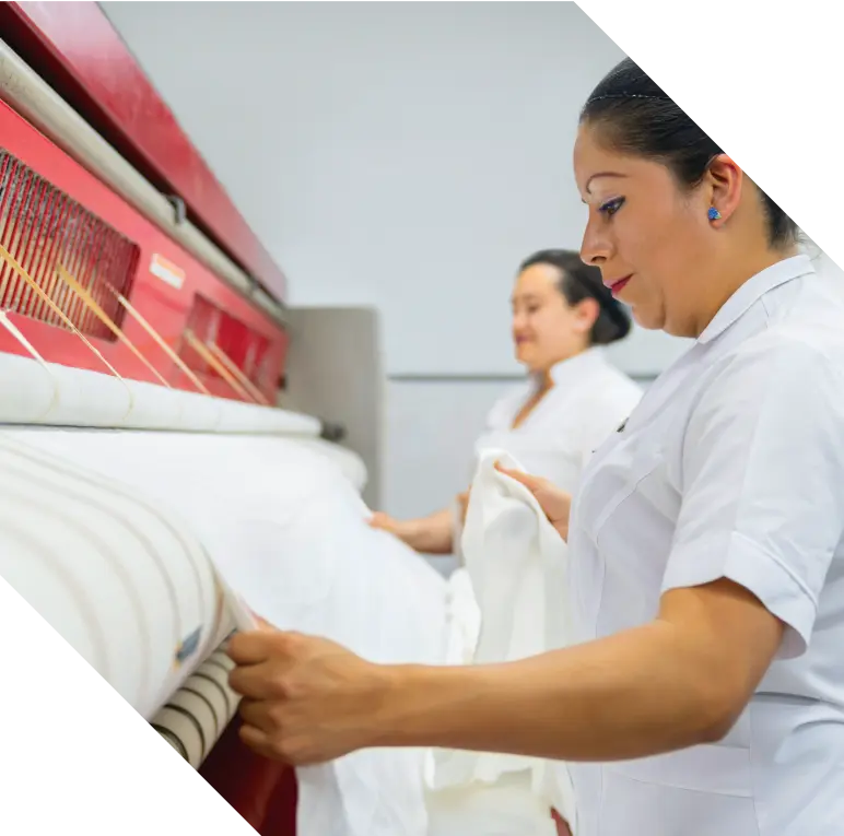  2 workers on industrial laundry machine